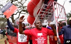 Kenya Corruption: Demonstrators carry a mock hospital bed covered in fake blood to illustrate the slogan that Kenyans are bleeding due to poor hospital services caused by corruption, in Nairobi, Kenya Thursday, Nov. 3, 2016.