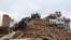 People survey a site damaged by an earthquake, in Kathmandu, Nepal, April 25, 2015.