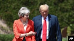 British Prime Minister Theresa May walks with President Donald Trump prior to a joint press conference at Chequers, in Buckinghamshire, England, July 13, 2018.