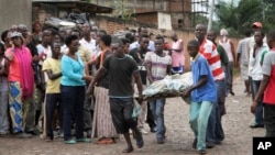 Men carry away a dead body in the Nyakabiga neighborhood of Bujumbura, Burundi, Dec. 12, 2015. 