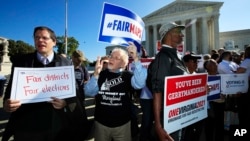 Protesters join others in a rally for fair elections, outside the U.S. Supreme Court in Washington, Oct. 3, 2017.