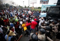 Demonstrators scuffle with the police during a protest calling for the resignation of President Jovenel Moise, near the airport in Port-au-Prince, Haiti, Oct. 4, 2019.