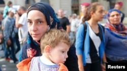 Migrants leave the main Eastern Railway station in Budapest, Hungary, Sept. 1, 2015.