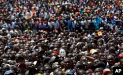 Supporters of opposition leader Raila Odinga, one wearing a mask, attend a mock "swearing-in" ceremony at Uhuru Park in downtown Nairobi, Kenya, Jan. 30, 2018.