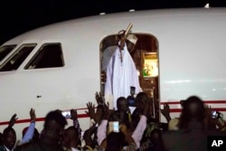 Gambia's defeated leader Yahya Jammeh waves to supporters as he departs from Banjul airport, Jan. 21, 2017.