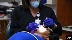 FILE - In this photo provided by U.S. Immigration and Customs Enforcement, a patient receives care at South Texas Family Residential Center in Dilley, Texas, Aug. 9, 2018.