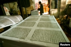 FILE - A worker looks checks printing paper for the Koran near the Sunan Ampel mosque in Surabaya, Indonesia East Java province, July 27, 2011.