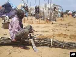 A man from drought-stricken southern Somalia cuts tree branches to construct a makeshift shelter in refugee camp in the capital, Mogadishu.