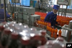 FILE - A worker monitors the production of bottled beverage at Songdowon General Foodstuffs Factory in Wonsan, North Korea, Oct. 22, 2018.