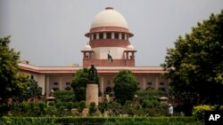 FILE - A gardener works on the lawns of the Supreme Court in New Delhi, India, Aug. 22, 2017. India's Chief Justice of the Supreme Court has presided over a string of verdicts in recent weeks that grant more rights to women, gay couples and religious minorities as he prepares to retire from the bench next month.