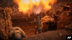 Ukrainian servicemen of the 28th Separate Mechanised Brigade fire a 122mm mortar toward Russian positions at the front line, near Bakhmut, Donetsk region, Ukraine, March 3, 2024.