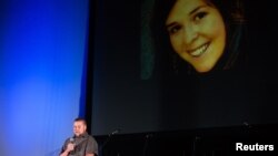 Eric Mueller reads a poem about his late sister, aid worker Kayla Mueller, at the Prescott's Courthouse Square in Prescott, Arizona, Feb. 18, 2015. 