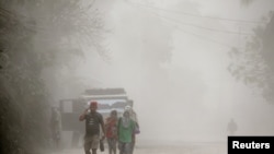 A family evacuates to safer grounds as Taal volcano in Tagaytay, Cavite province, southern Philippines, Jan. 13, 2020.