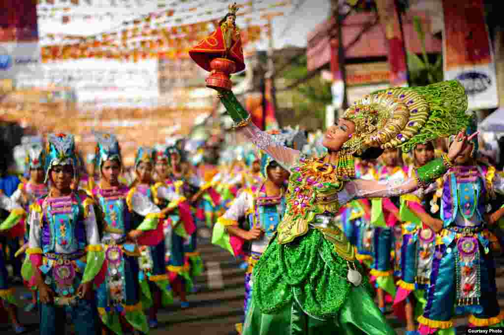 Para peserta dengan mengenakan kostum yang 'menyala' berpartisipasi dalam parade di Kota Cebu, Filipina, untuk merayakan Sinulog, festival tahunan untuk memperingati penerimaan agama Katolik Roma oleh penduduk asli di Cebu.