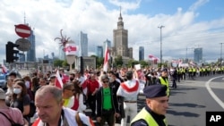 People carry banners of protest as they gather to denounce the regime of Belarusian President Alexander Lukashenko in Warsaw, Poland, Aug. 8, 2021.