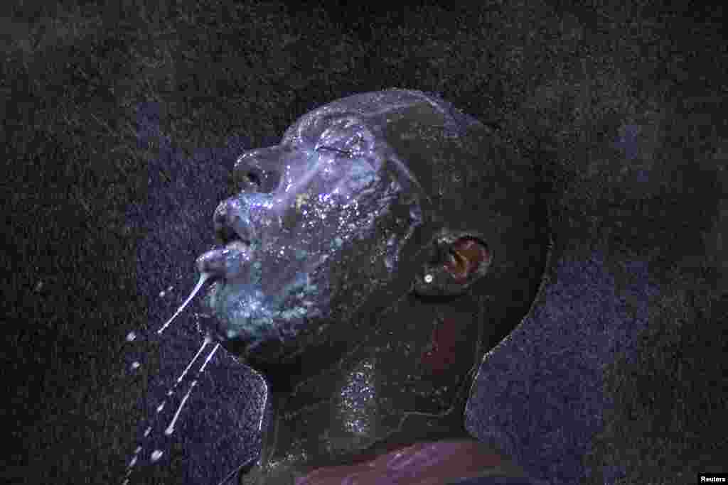 A man is doused with milk and sprayed with mist after being hit by an eye irritant from security forces trying to disperse demonstrators protesting against the shooting of unarmed black teen Michael Brown in Ferguson, Missouri, USA.