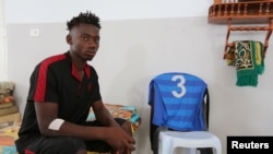 Seorang migran Afrika, yang menurut sumber pemerintah diselamatkan setelah kapal yang dia tumpangi, terbalik di Laut Tengah, lepas pantai Tunisia, dudul di knator Bulan Sabit Merah setempat di Zarzis, Tunisia, 4 Juli 2019.
