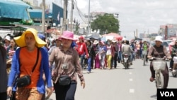 ក្រុមកម្មករ​ចេញ​ពី​រោងចក្រ​ពេល​ថ្ងៃត្រង់ ដើរ​ឆ្ពោះ​ទៅ​ផ្សារ​ក្បែរ​រោងចក្រ​ដើម្បី​សម្រាក​ និង​បរិភោគ​អាហារ​ថ្ងៃត្រង់​រយៈពេល​ប្រមាណ​មួយ​ម៉ោង។ (ខាន់ សុគុំមនោ/VOA)