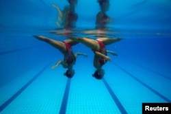 FILE - Brazil's synchronized swimmers Maria Eduarda Miccuci (R) and Luisa Borges perform during a photo session at the Rio Olympic Park in Rio de Janeiro, Brazil, April 29, 2016.