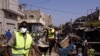 Des employés municipaux portant des masques à titre préventif contre le coronavirus COVID-19 nettoient les étals autour du marché Tilene à Dakar le 22 mars 2020 suite à la décision du maire de nettoyer les étals et de fermer les marchés tous les soirs à p