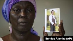In this Monday, May 19, 2014 file photo, Martha Mark, the mother of kidnapped school girl Monica Mark cries as she displays her photo, in the family house, in Chibok, Nigeria.