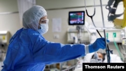 FILE - A medical worker takes care a patient at the intensive care unit (ICU) of the Emergencias de Villa El Salvador hospital, during the outbreak of the coronavirus disease (COVID-19), in Lima, Peru, Dec. 22, 2020. 