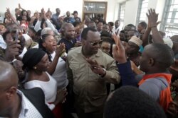 FILE - Freeman Mbowe, center, chairman of Chadema, Tanzania's main opposition party, arrives at Kisutu Magistrate Court in Dar es Salaam, Tanzania, March 10, 2020.