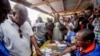 Ghana Incumbent President, John Dramani Mahama candidate of the National Democratic Congress, second left, validates his name before casting his vote during the Presidential and parliamentary election, in Bole Ghana, Wednesday, Dec. 7, 2016.
