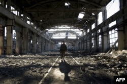 FILE - An Ukrainian serviceman walks through the rubble of a destroyed workshop after fighting with pro-Russian separatists in Avdiivka, Donetsk region, March 31, 2017.