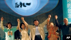 Taipei's mayor-elect, Ko Wen-je, center, raises his arms with family and friends to cheer with supporters at his campaign headquarters, Nov. 29, 2014.