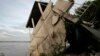 FILE - A local house damaged by floods leans toward the Mekong River in Koh Norea village in Phnom Penh, Cambodia, Thursday, Dec. 8, 2011.