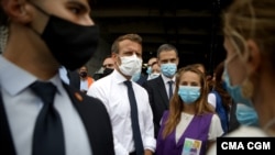 French President Emmanuel Macron, second from left, listen to members of local NGOs unloading emergency aid delivered for Lebanon at Beirut port, Sept. 1, 2020. 