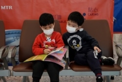 Passengers wear masks to prevent an outbreak of a new coronavirus in the high speed train station, in Hong Kong, Jan. 22, 2020.