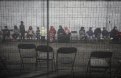 Afghan refugees queue outside a distribution and donation center in Liberty Village on Joint Base McGuire-Dix- Lakehurst in Trenton, N.J., Dec. 2, 2021.