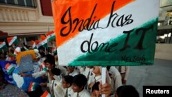 Students cheer as they raise flags to celebrate after India shot down one of its satellites in space with an anti-satellite missile in a test, inside their school premises in Ahmedabad, India, March 27, 2019.
