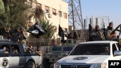 An image made available by Jihadist media outlet Welayat Raqa on June 30, 2014, allegedly shows a member of the IS (Islamic state) militant group parading in a street in the northern rebel-held Syrian city of Raqqa.