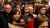 A Catholic worshiper carries her daughter as Archbishop Pizzaballa (not seen), apostolic administrator of the Latin Patriarch of Jerusalem, leads the Christmas Midnight Mass in Saint Catherine's Church at the Church of the Nativity, Dec. 25, 2016.