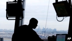 FILE - An air traffic controller works in the tower at Newark Liberty International Airport in Newark, N.J., May 21, 2015.