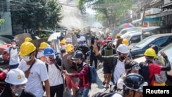 Pengunjuk rasa lari dari kejaran polisi dalam aksi protes menentang kudeta militer di Yangon, Myanmar, 8 Maret 2021. REUTERS / Stringer