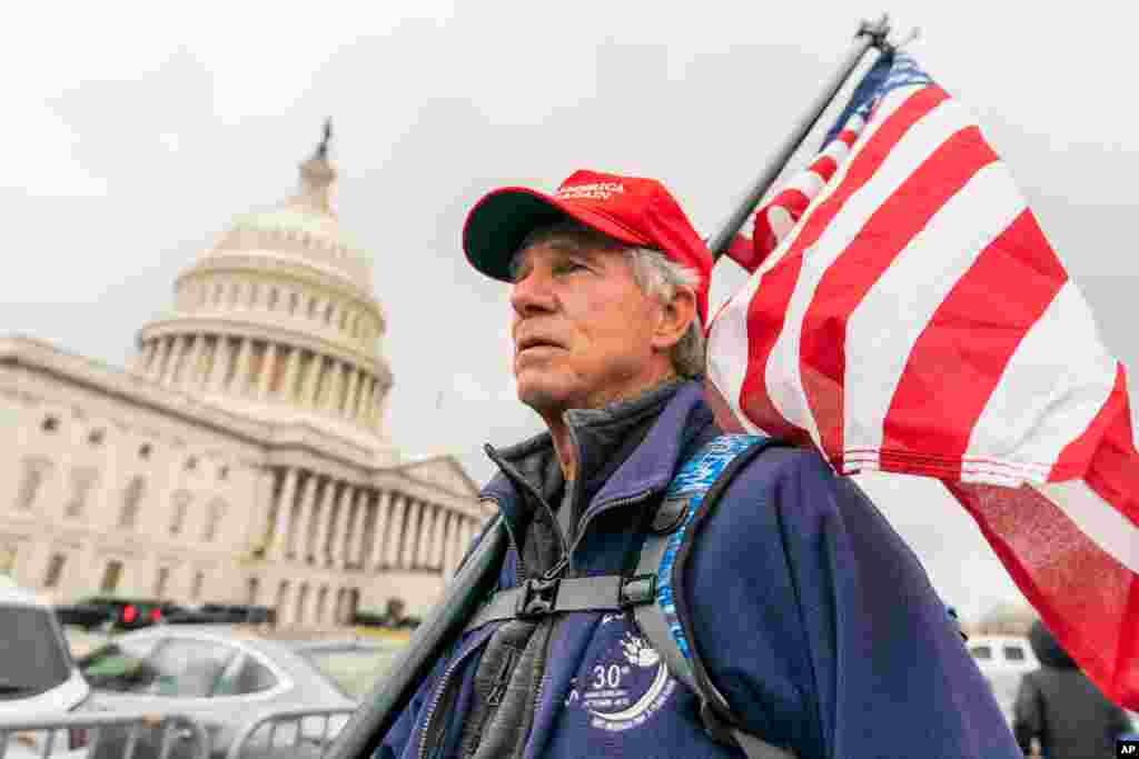 Lloyd Watkins of Nashville, Tenn., a supporter of President Donald Trump carries a flag outside the Capitol, Jan. 5, 2021.