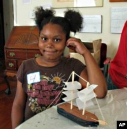 Children who visit the Amistad exhibit make their own version of the ship, which includes outlines of the chained slaves inside the hull.