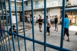 FILE - Chinese laborers at the Imperial Pacific Casino gather in front of their living quarters before a protest in Saipan, the Northern Mariana Islands, July 26, 2017.