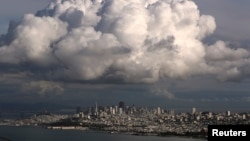 A large cloud gathers over the skyline of San Francisco, California, Dec. 12, 2014. While the Pacific Northwest is expected to have a mild winter, California's forecast is unsure.