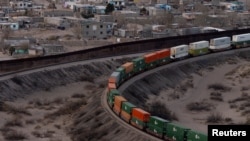 A train travels along the US side close to a portion of the border wall along the U.S.-Mexico border between Cuidad Juarez, Mexico and Sunland Park, New Mexico, as seen from Mount Cristo Rey in El Paso, Texas, Feb. 26, 2025. 