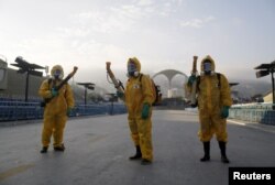 Municipal workers wait before spraying insecticide at Sambodrome in Rio de Janeiro, Brazil, Jan. 26, 2016.