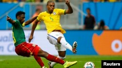 Brazil's Fernandinho (R) shoots to score past Cameroon's Nicolas Nkoulou during their 2014 World Cup Group A soccer match at the Brasilia national stadium in Brasilia, June 23, 2014. 