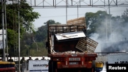 A damaged truck, that was used to transport humanitarian aid, is seen on the Francisco de Paula Santander cross-border bridge between Colombia and Venezuela, after clashes with opposition supporters and Venezuela's security forces, in Cucuta, Feb. 24, 2019.
