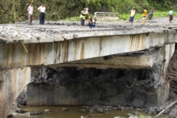 People look at a bomb-damaged bridge outside the compound of the Gote Twin police station in Shan State, Aug. 15, 2019.
