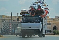 FILE - Syrian civilians flee a conflict zone in Syria's rebel-held northwestern region of Idlib, near Maar Shurin on the outskirts of Maaret al-Numan. Damascus, Aug. 22, 2019.