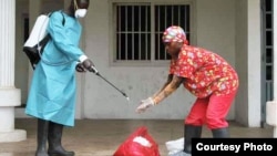 A Liberian Red Cross employee disinfects after removing a body suspected of having Ebola, Monrovia, September 2014. (Credit: International Alert)
